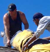 Manuvering bundles on the roof.